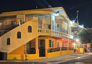 A two-story building with a yellow facade, a balcony on the upper floor, and a sign for 'The Perch' restaurant.