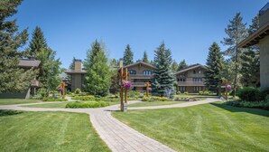 A courtyard with a paved walkway, surrounded by well-maintained lawns and trees. - Sun Valley retreat at Lodge II Condos with garage and Resort Amenities (Sun Valley)