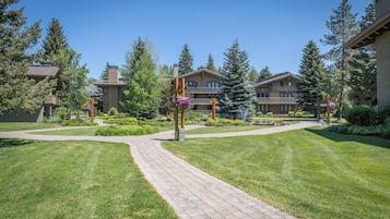 A courtyard with a paved walkway, surrounded by well-maintained lawns and trees.