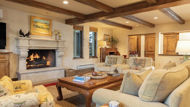 A cozy living room with a fireplace, comfortable seating, and wooden beams on the ceiling. - Sun Valley retreat at Lodge II Condos with garage and Resort Amenities (Sun Valley)