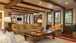 A cozy living room with a wooden coffee table, checkered sofas, and a yellow armchair. - Sun Valley retreat at Lodge II Condos with garage and Resort Amenities (Sun Valley)