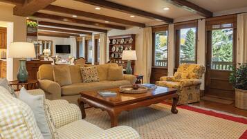 A cozy living room with a wooden coffee table, checkered sofas, and a yellow armchair.