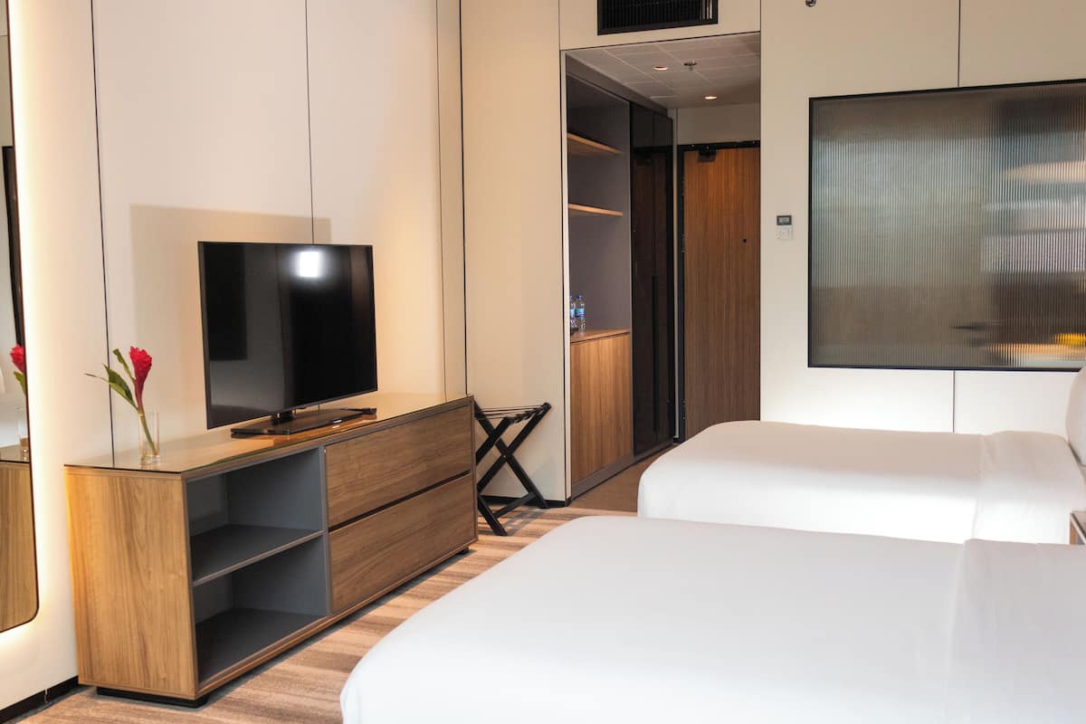 Relax in a spacious room with a large bed, flat-screen TV, and city views.