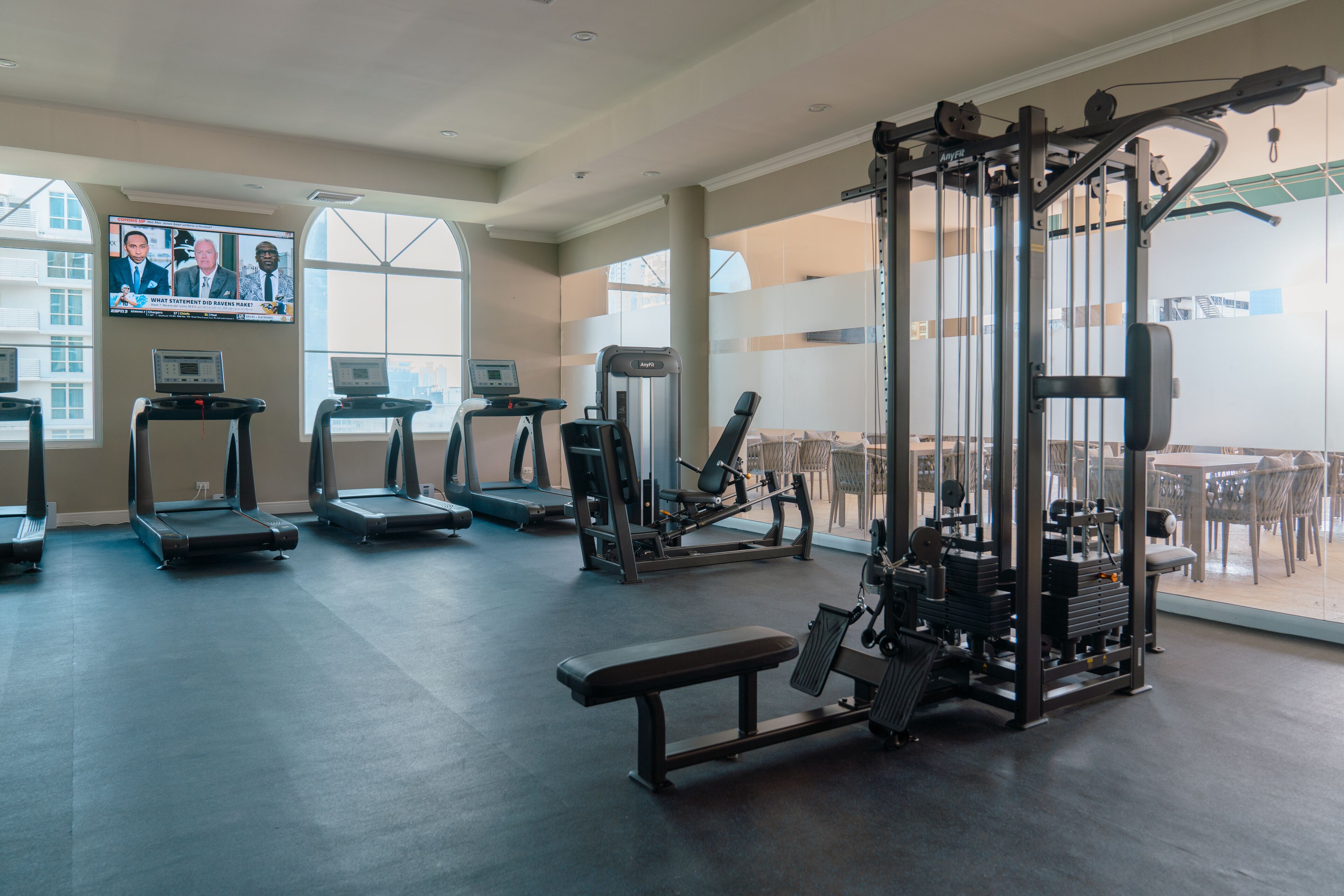 A gym with treadmills, a bench, and weight machines.