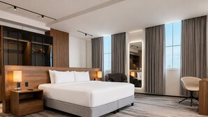 A modern hotel room with a large bed, a desk, a chair, and a wardrobe. - Waymore Hotel Spa & Casino (Panama City)