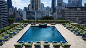 A rooftop pool with sun loungers and a city skyline in the background. - Waymore Hotel Spa & Casino (Panama City)