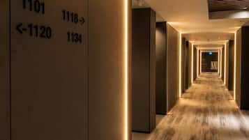 A hotel corridor with illuminated wall numbers indicating room locations.