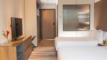 Una habitación de hotel con televisión, cama, escritorio y ventana.