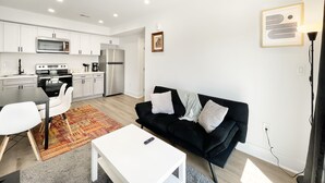 A modern apartment with a kitchen, living room, and dining area. - Cozy Petworth Stay with Balcony & Courtyard View (Washington)