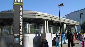 A modern transit station with a prominent 'M' sign, indicating a metro station. - Petworth Luxury Unit with Modern Comforts (Washington)