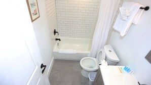 Un baño con bañera, inodoro y lavamanos.