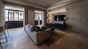 A modern living room with a sofa, a TV, and a sliding door. - Modern Luxury Penthouse with Terrace (Roma)