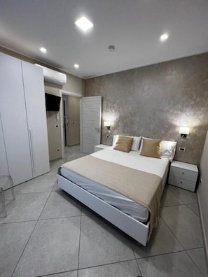 A modern bedroom with a bed, bedside tables, a wardrobe, and a closet. - Apartment*3 Lamezia Central Airport "CORALLO" (Santa Eufemia Lamezia)