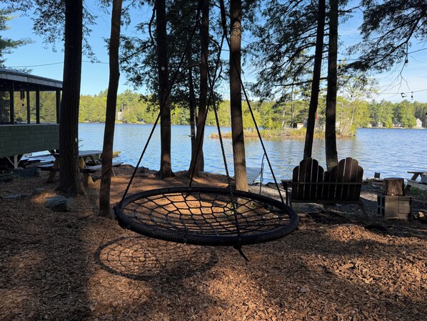 A hammock swing, picnic tables, and a lake view.