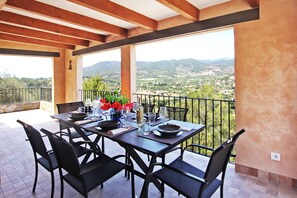 A dining area with a table set for four, overlooking a scenic landscape. - Villa Ses Costes with private pool, garden and panoramic views of the mountains in Alaró  (Alaro)
