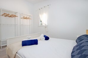 A bedroom with a bed, a wardrobe, and a window with curtains. - Villa Ses Costes with private pool, garden and panoramic views of the mountains in Alaró  (Alaro)