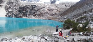 Un paisaje rocoso con un lago azul cristalino y una cascada.