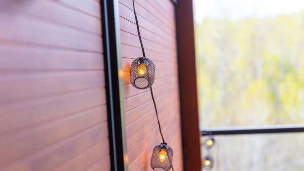 Eine Lichterkette an einer Holzwand.