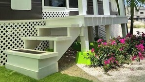 A recreational vehicle with a white deck and steps leading up to the entrance. - The Lazy Turtle Inn + Beach & Pool (Key Largo)