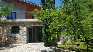 A stone pathway leading to a wooden house with a stone wall and a glass door. - Cevennes Nature Entourée de Végétation, à 3mn de la Rivière, à 1mn de la Piscine (Chambon)