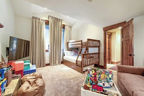A bedroom with a bunk bed, a television, a desk with toys, and a window with curtains. - 2430 Ultimate Deer Valley Getaway Hot Tub and 2 Gold Utah Ski Passes (Park City)