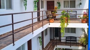 A multi-level residential building with balconies, railings, and potted plants. - blue Bocana Hotel (Santa María Huatulco)