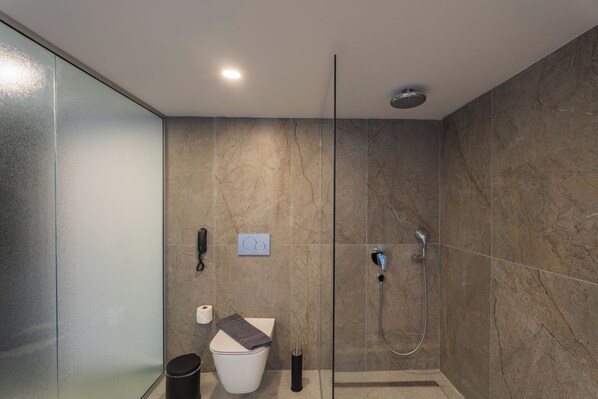 Une salle de bain moderne avec une douche à parois de verre, des toilettes et un bidet.