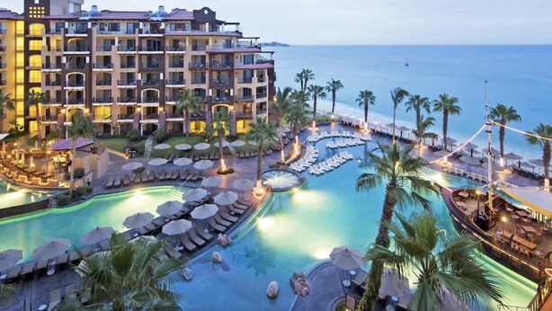 A resort with a large pool, multiple lounge areas, and a view of the ocean. - Villa del Arco  Beach Front. Grocery store on site or short ride. Full Kitchen.  (Cabo San Lucas)
