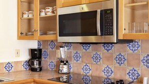 A kitchen with a stainless steel microwave, a coffee maker, and a blender on the counter. - Villa del Arco  Beach Front. Grocery store on site or short ride. Full Kitchen.  (Cabo San Lucas)