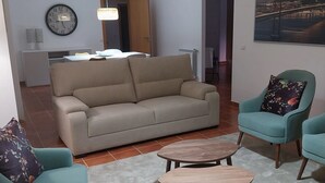 Un soggiorno con un divano, due poltrone, un tavolino, una sveglia, un quadro e una porta che dà su un'altra stanza.