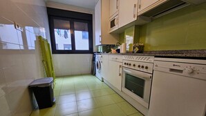 Cocina con lavadora, horno y microondas.