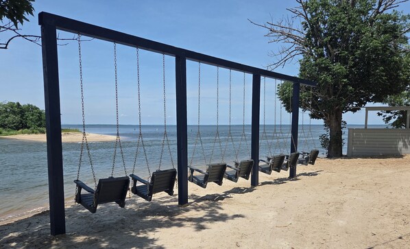 A beach swing set with a view of the sea.