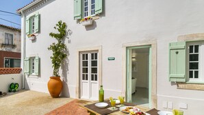 A patio with a table set for a meal, a large potted plant, and a sign reading "CICERIA." - Perfect refuge in the city heart, 2 mins from the river, lakes and green spaces (Leiria)