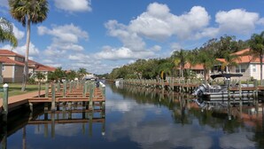 Una vía fluvial tranquila con muelles, barcos y casas de tejados rojos.