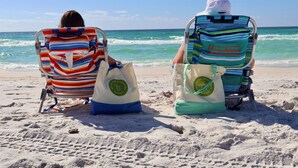 Two beach chairs with bags on a sandy beach with the ocean in the background. - Family Friendly | Walk to Beach & Dining | Firepit (Santa Rosa Beach)