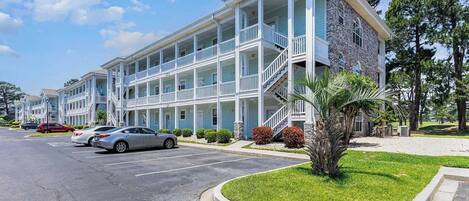 A multi-story motel with a central courtyard, featuring balconies and a stone facade.