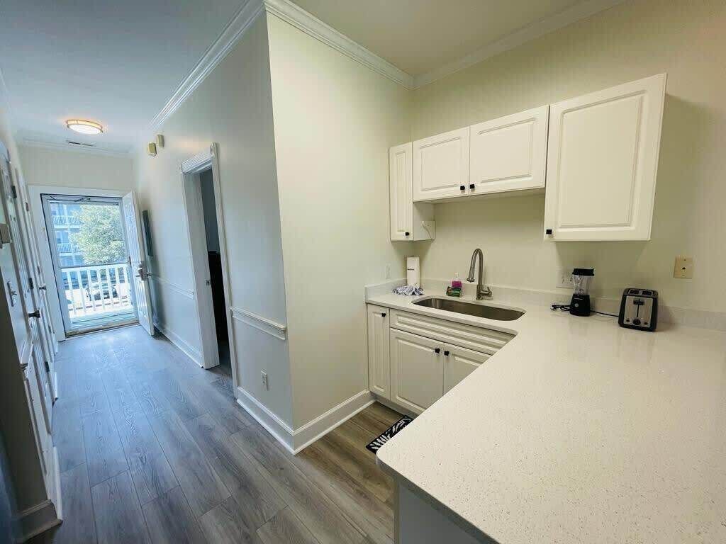 A kitchen with white cabinets, a countertop, and a sink.