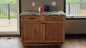 Una cocina con armarios de madera, encimera de granito y vistas al exterior.