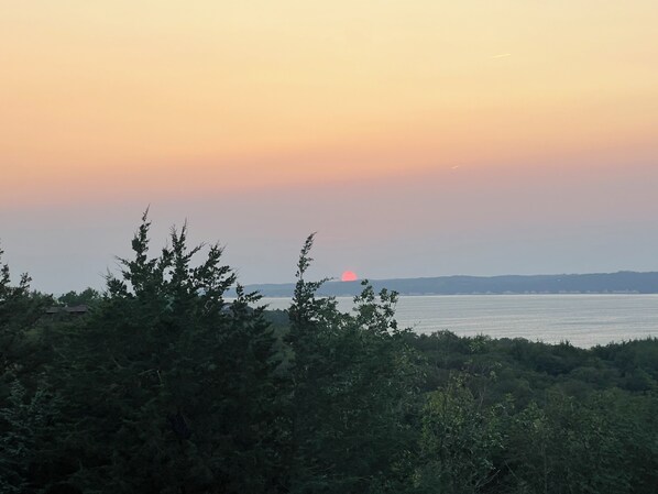 A sunset over a body of water with trees in the foreground. - Beautiful newly renovated home overlooking Lewis and Clark lake. (Crofton)