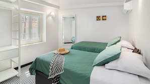 Un dormitorio con dos camas, una ventana, un armario y un espejo.
