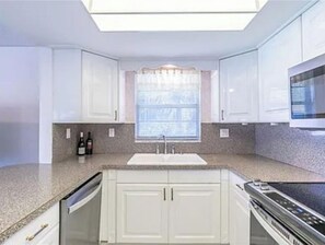 Kitchen features an oven, microwave, and stainless steel range.