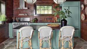 A rustic kitchen with wooden walls, a central island with bar stools, and hanging light fixtures. - The Peregrine: Flat Mountain Farm - expansive luxury home on historic 28 acre rhododendron farm (Highlands)