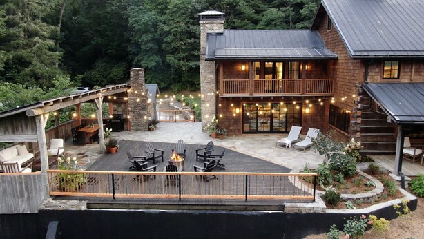 A cabin with a covered patio, outdoor seating, and string lights. - The Peregrine: Flat Mountain Farm - expansive luxury home on historic 28 acre rhododendron farm (Highlands)