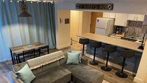 A modern apartment with a living room, dining area, and kitchen. - Mountainside ski-in condo near Ski Time Square  (Steamboat Springs)