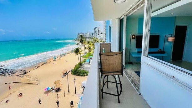 Een balkon met uitzicht op een strand en de oceaan.