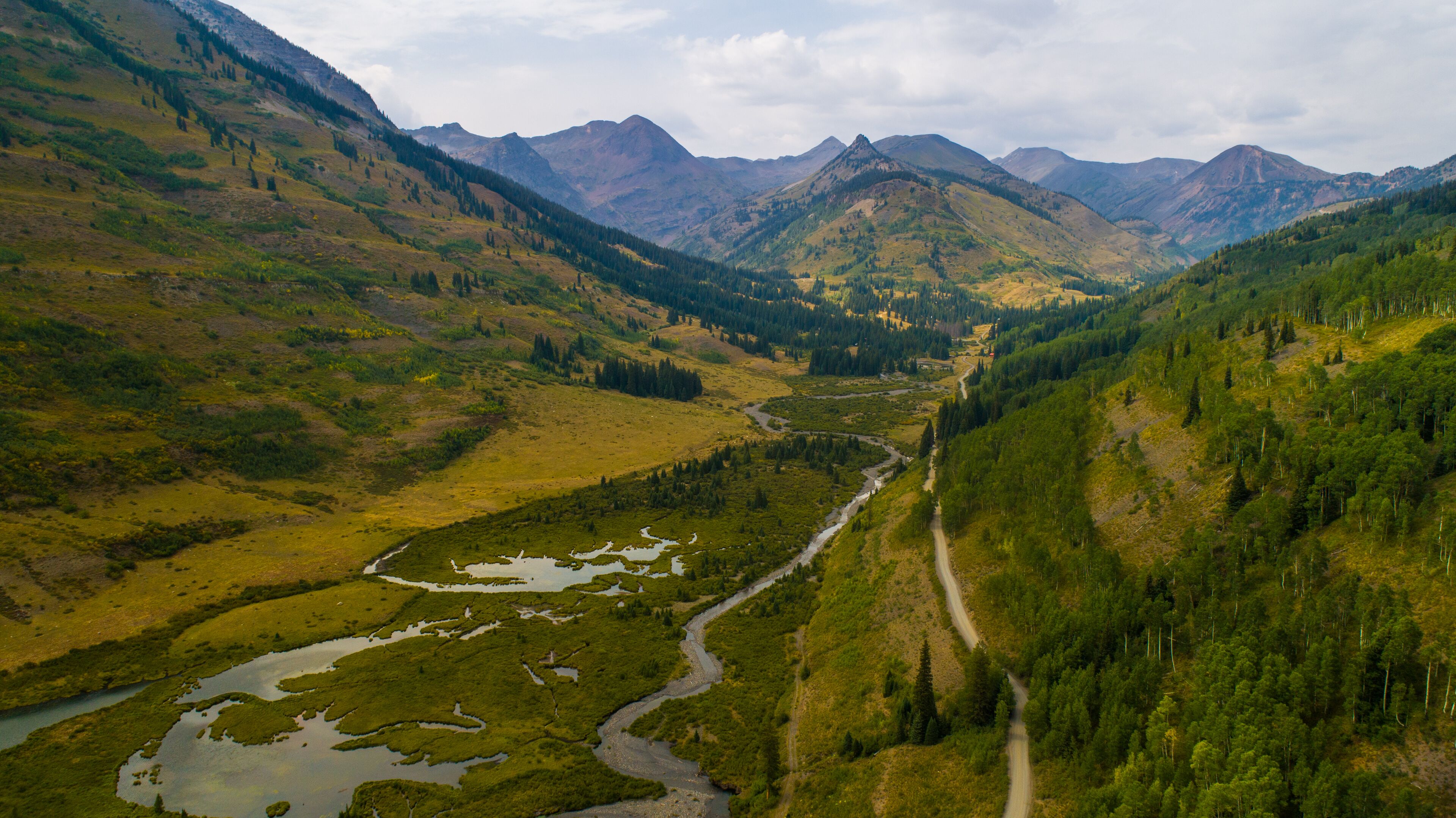 A mountainous landscape with a river and a road.