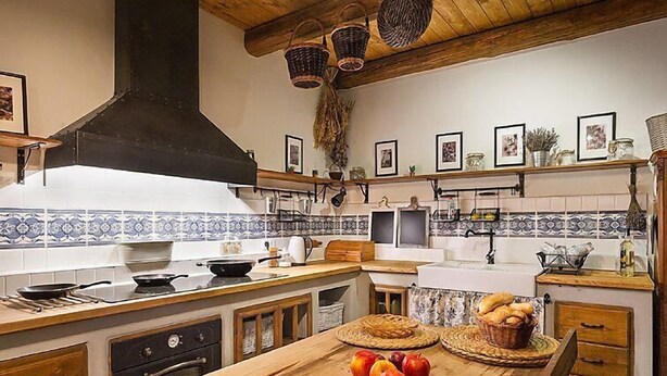 Una cocina con una isla de madera, una estufa y diversos utensilios.