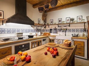 A kitchen with a wooden island, a stove, and various kitchen items. - Vacation home Huty by Interhome (Jimramov)