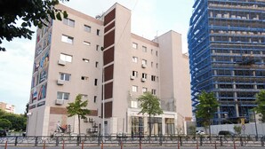 Ein mehrstöckiges Gebäude mit modernem architektonischen Design, das Wohn- und Gewerbeflächen vereint.