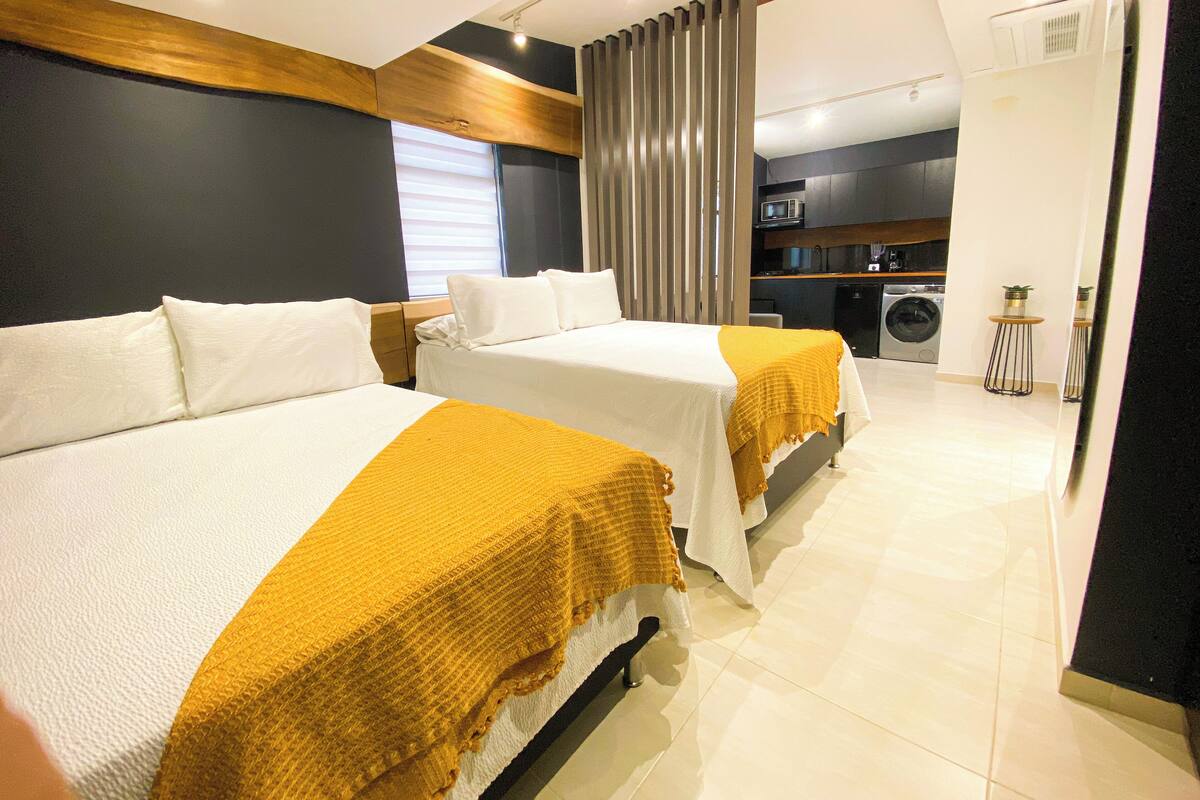 Une chambre d’hôtel avec deux lits, un lave-linge et une kitchenette.